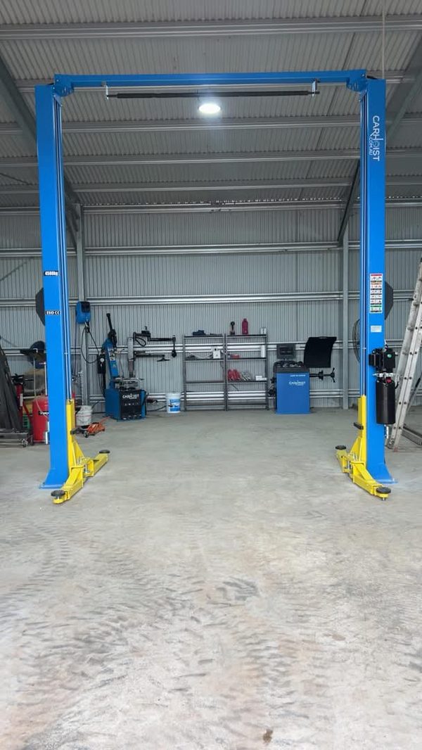 Darlington Hire & Tyre workshop shed with a blue two-post car hoist, tyre changer and wheel balancer