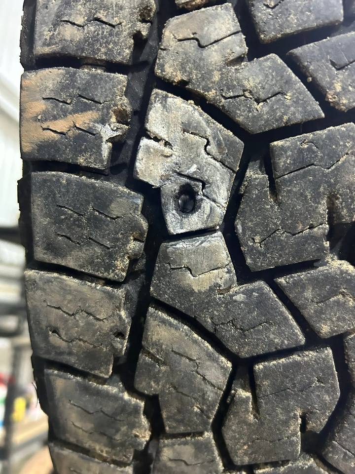 Close-up of an all-terrain tyre tread with a puncture hole